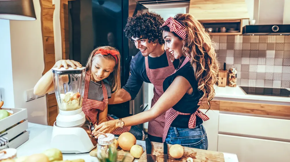 family cooking in kitchen using blender